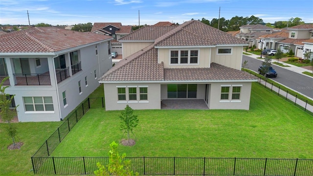 rear view of house with a balcony and a lawn