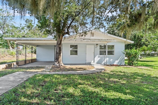 view of front of property with an attached carport, concrete driveway, and a front lawn