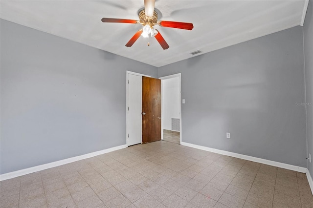 unfurnished room featuring a ceiling fan, visible vents, and baseboards