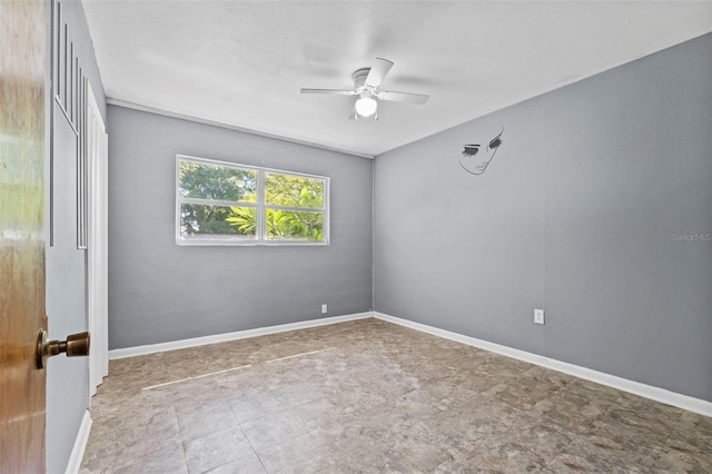 unfurnished room featuring ceiling fan and baseboards