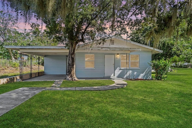 view of front of property featuring a carport, driveway, and a front lawn