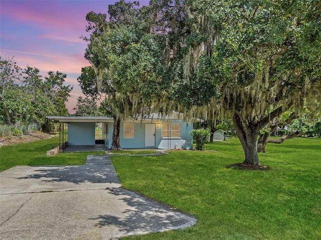 view of front of property with an attached carport, driveway, and a front yard