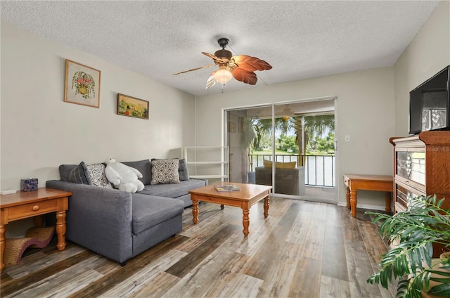 living room with hardwood / wood-style floors, ceiling fan, and a textured ceiling