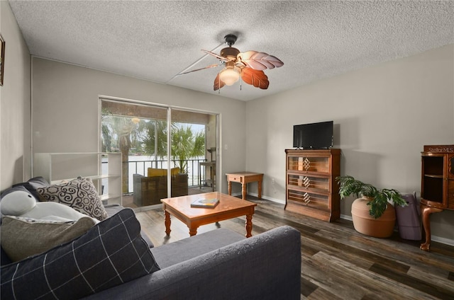 living room with dark hardwood / wood-style flooring, ceiling fan, and a textured ceiling