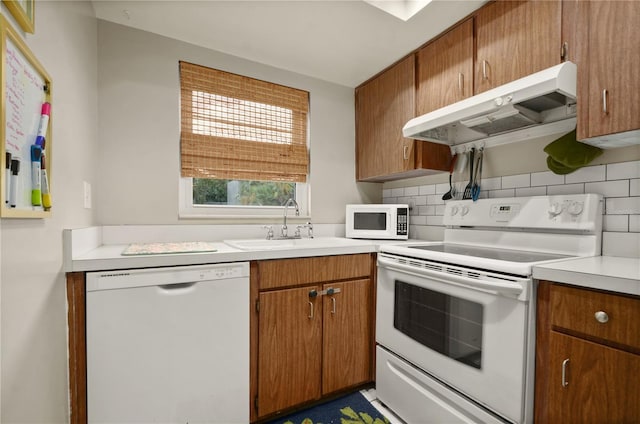 kitchen featuring sink, white appliances, and tasteful backsplash