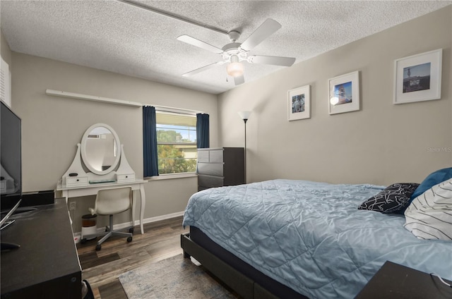 bedroom featuring ceiling fan, dark hardwood / wood-style flooring, and a textured ceiling