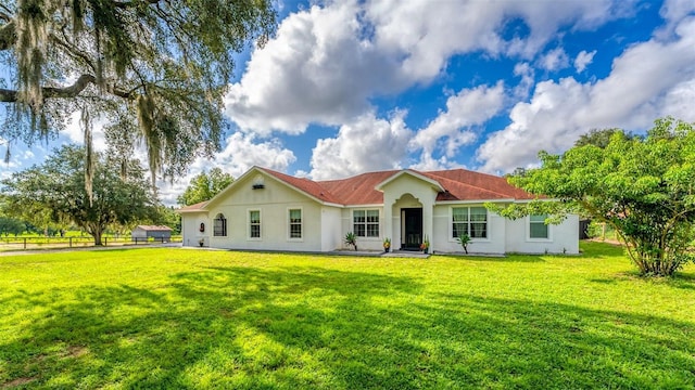 rear view of house featuring a yard