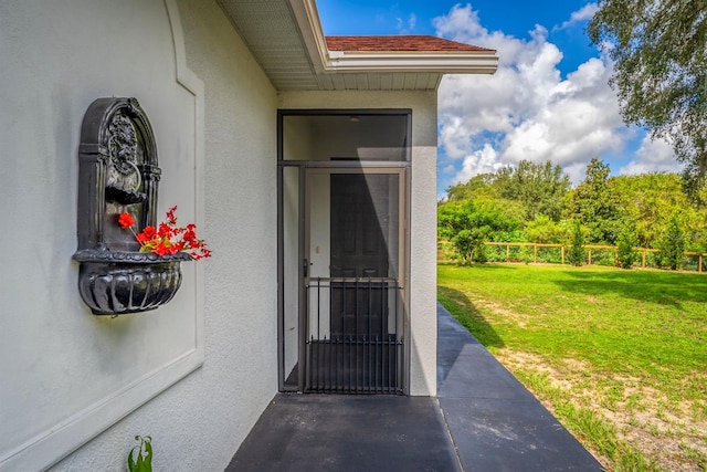 doorway to property featuring a lawn