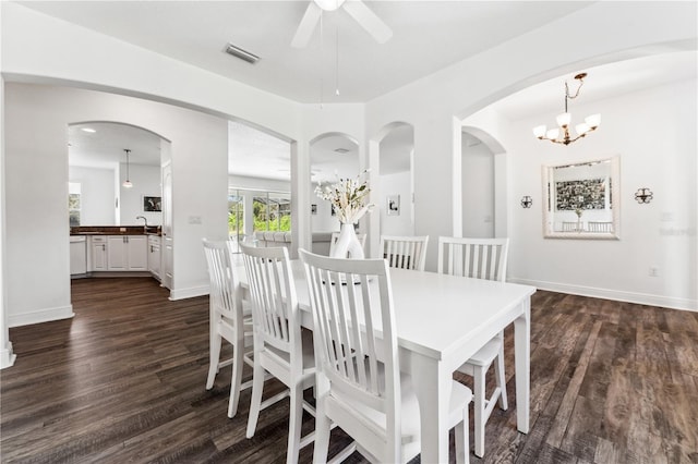 dining area featuring ceiling fan with notable chandelier, dark hardwood / wood-style floors, and sink