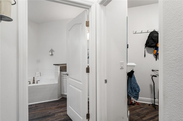 bathroom with hardwood / wood-style floors and tiled bath