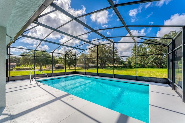 view of swimming pool with a yard, a patio area, and glass enclosure