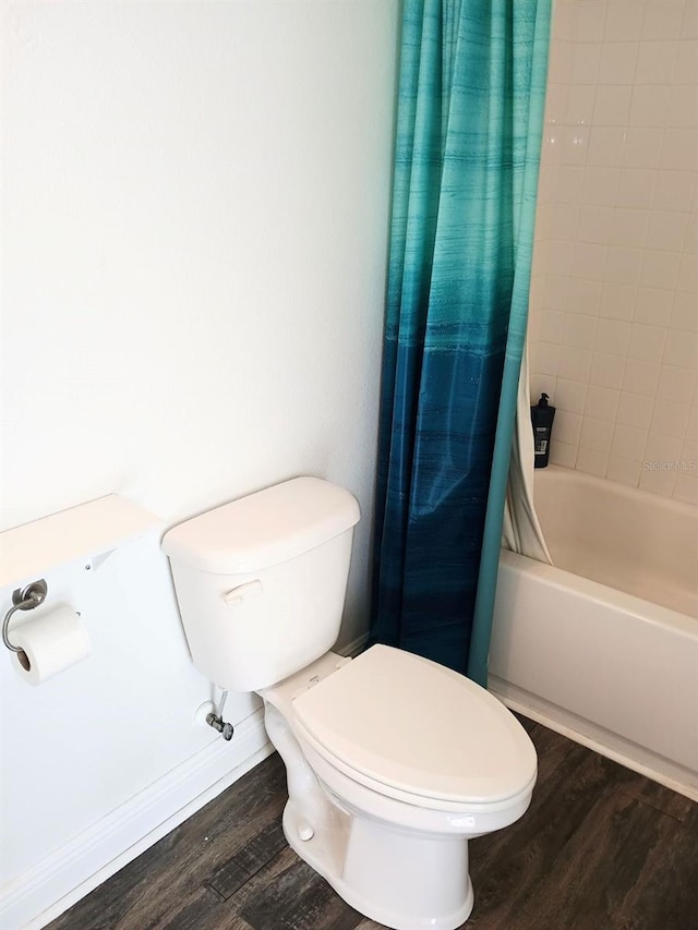 bathroom with shower / bath combo, toilet, and hardwood / wood-style flooring