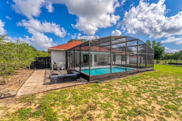 view of swimming pool with a yard, a patio area, and glass enclosure