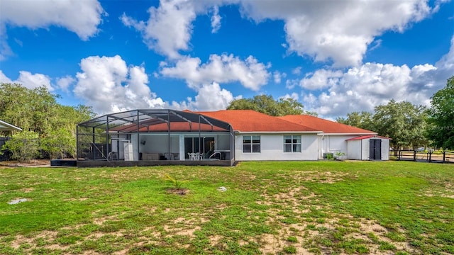 back of house with a lanai and a yard