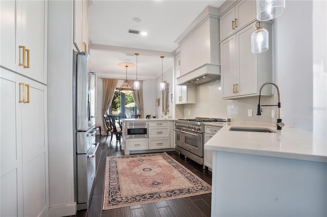 kitchen featuring stainless steel appliances, kitchen peninsula, dark wood-type flooring, and sink