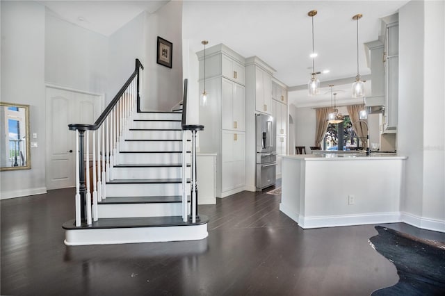 kitchen with pendant lighting, kitchen peninsula, dark hardwood / wood-style floors, and high end refrigerator