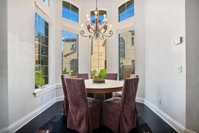 dining room with a high ceiling, plenty of natural light, and a notable chandelier