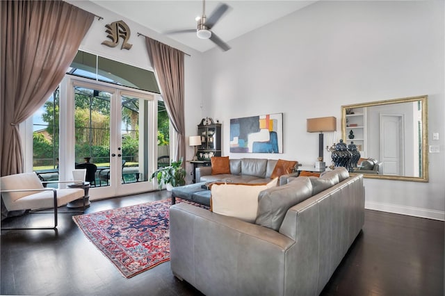 living room featuring a high ceiling, ceiling fan, dark hardwood / wood-style floors, and french doors