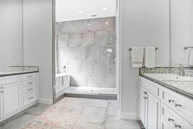 bathroom featuring tile patterned flooring, an enclosed shower, and vanity