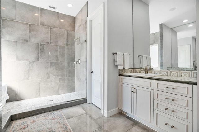 bathroom with a tile shower, tile patterned floors, and vanity