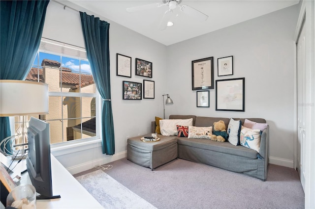 carpeted living room with ceiling fan