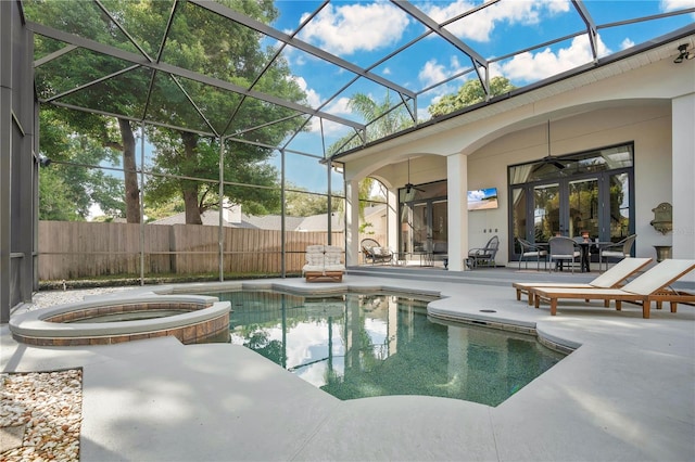 view of swimming pool with ceiling fan, glass enclosure, a patio area, and an in ground hot tub