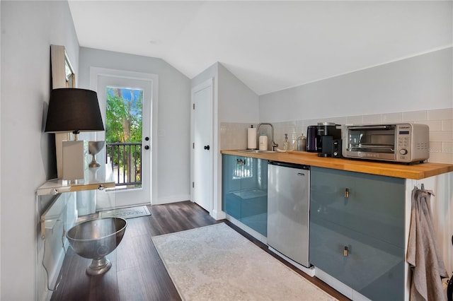 bar featuring dark wood-type flooring, lofted ceiling, stainless steel refrigerator, backsplash, and butcher block countertops