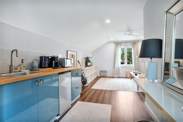 interior space featuring stainless steel fridge, vaulted ceiling, dark wood-type flooring, backsplash, and sink