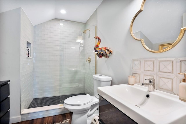 bathroom featuring wood-type flooring, lofted ceiling, vanity, and toilet