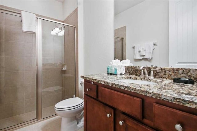 bathroom featuring vanity, toilet, walk in shower, and tile patterned floors