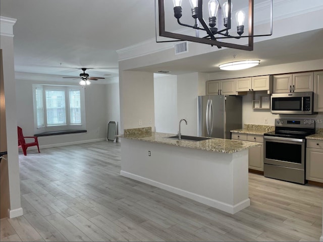 kitchen with light hardwood / wood-style floors, ceiling fan with notable chandelier, light stone countertops, stainless steel appliances, and sink