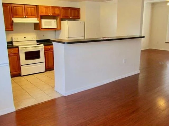 kitchen featuring white appliances and light hardwood / wood-style floors