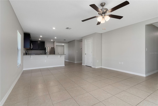 unfurnished living room with a healthy amount of sunlight, tile patterned flooring, and ceiling fan