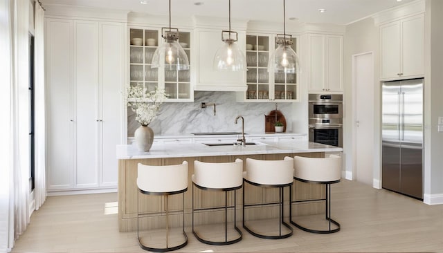 bar with tasteful backsplash, white cabinetry, light hardwood / wood-style flooring, hanging light fixtures, and appliances with stainless steel finishes