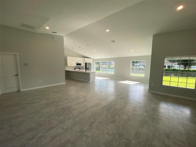 unfurnished living room with high vaulted ceiling