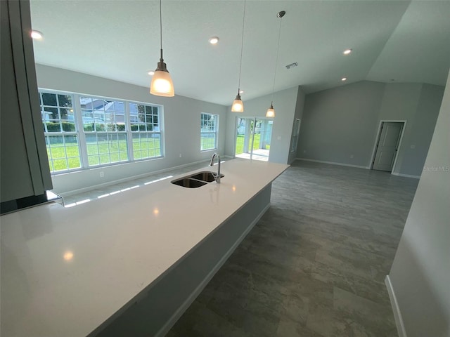 kitchen featuring vaulted ceiling, a wealth of natural light, sink, and hanging light fixtures