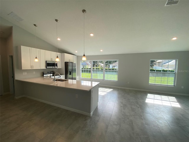 kitchen with stainless steel appliances, kitchen peninsula, sink, hanging light fixtures, and white cabinets