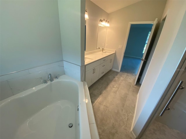 bathroom with vanity, a bath, tile patterned flooring, and lofted ceiling