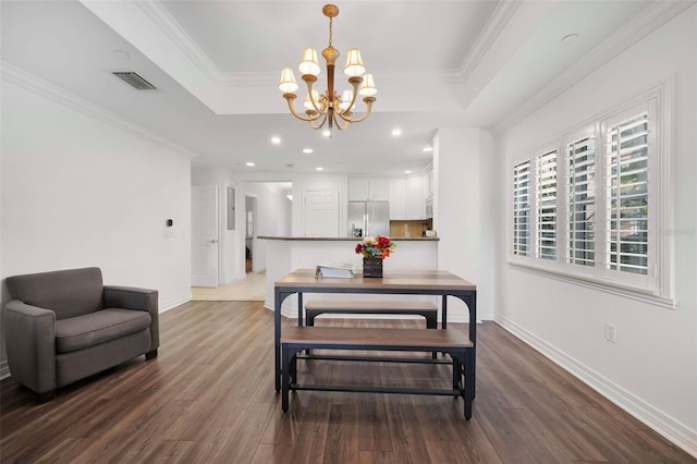 dining space with crown molding, dark wood-type flooring, and a raised ceiling