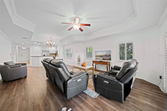 living room featuring ceiling fan with notable chandelier, a raised ceiling, crown molding, and dark hardwood / wood-style floors