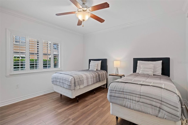 bedroom featuring ceiling fan, ornamental molding, and light hardwood / wood-style flooring