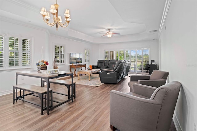 living room featuring ceiling fan with notable chandelier, a raised ceiling, ornamental molding, and hardwood / wood-style floors