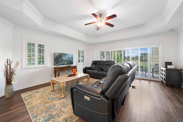 living room featuring a tray ceiling, ornamental molding, ceiling fan, and dark hardwood / wood-style floors