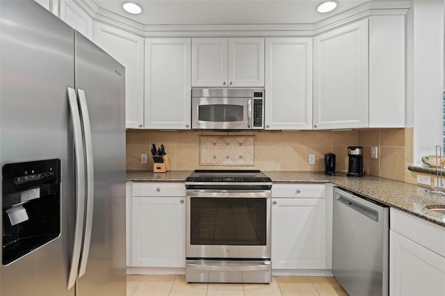 kitchen with appliances with stainless steel finishes, white cabinetry, and stone counters