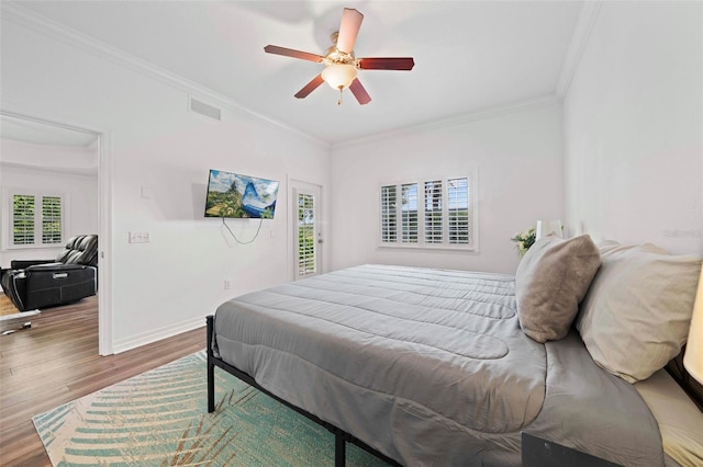 bedroom with crown molding, hardwood / wood-style flooring, and ceiling fan