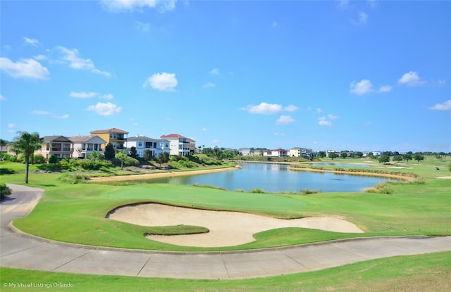 view of home's community with a water view and a lawn