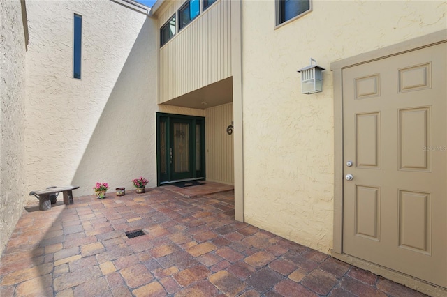 doorway to property with a patio area and stucco siding