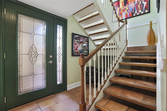 foyer entrance featuring vaulted ceiling, stairway, and baseboards