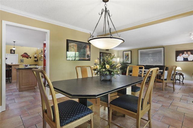 dining space with ornamental molding and baseboards