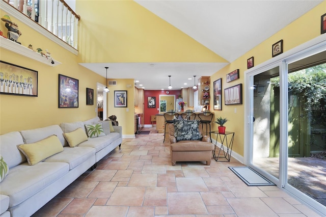 living room featuring high vaulted ceiling, visible vents, and baseboards